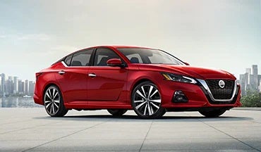 2023 Nissan Altima in red with city in background illustrating last year's 2022 model in Natchez Nissan in Natchez MS