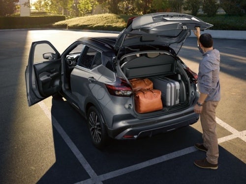 2024 Nissan Kicks view of man standing behind vehicle with back door open and cargo area full of bags